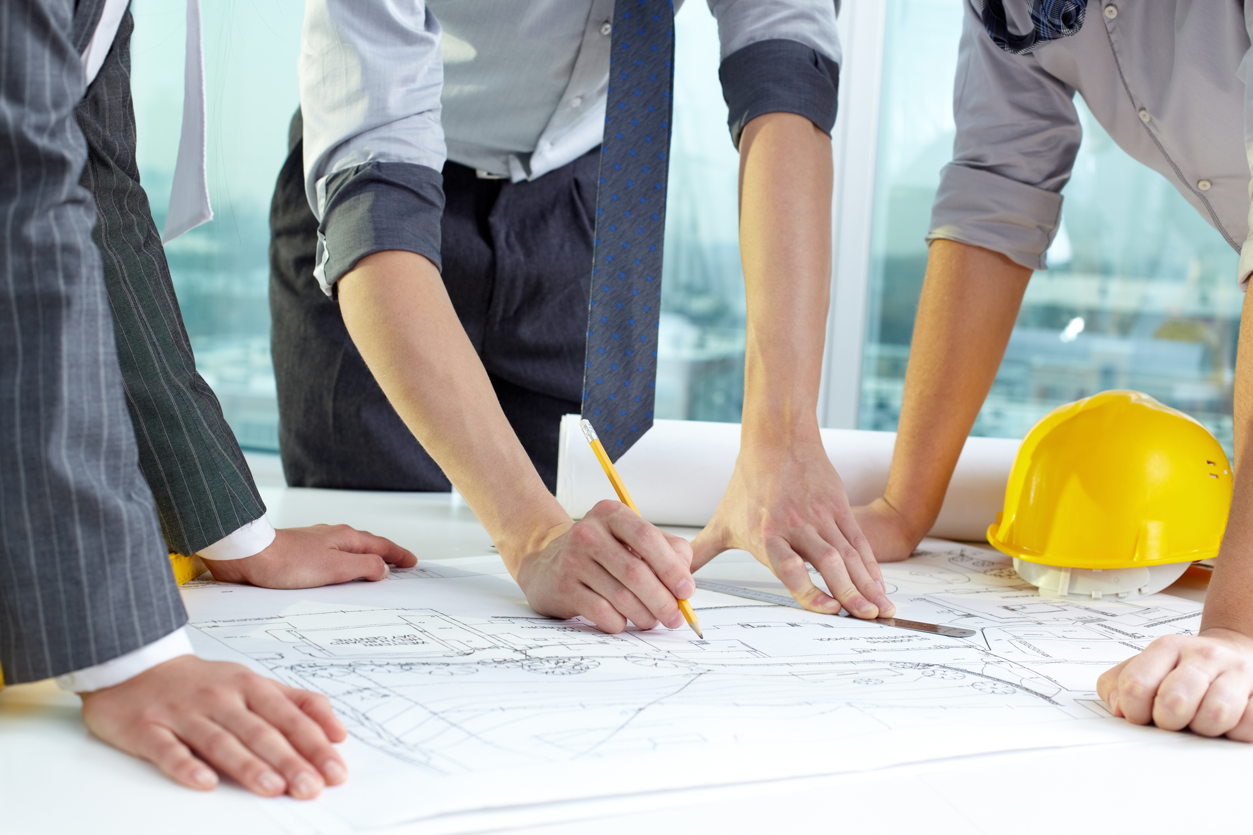 Engineering team reviewing crane plans with a customer